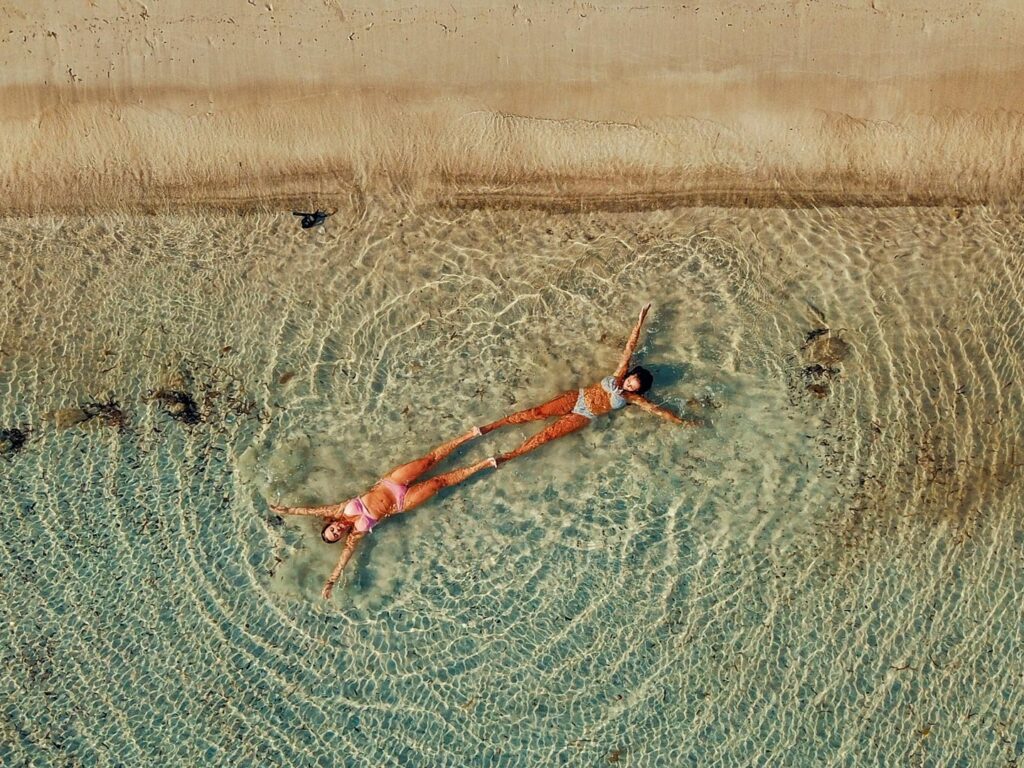 Crystal clear, emerald waters touching the golden sand of an untouched beach on Rhenia island, accessible only by private boat.