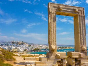 The iconic Portara at sunset viewed from the sea, an unforgettable perspective and one of the most famous things to do in Naxos Chora.