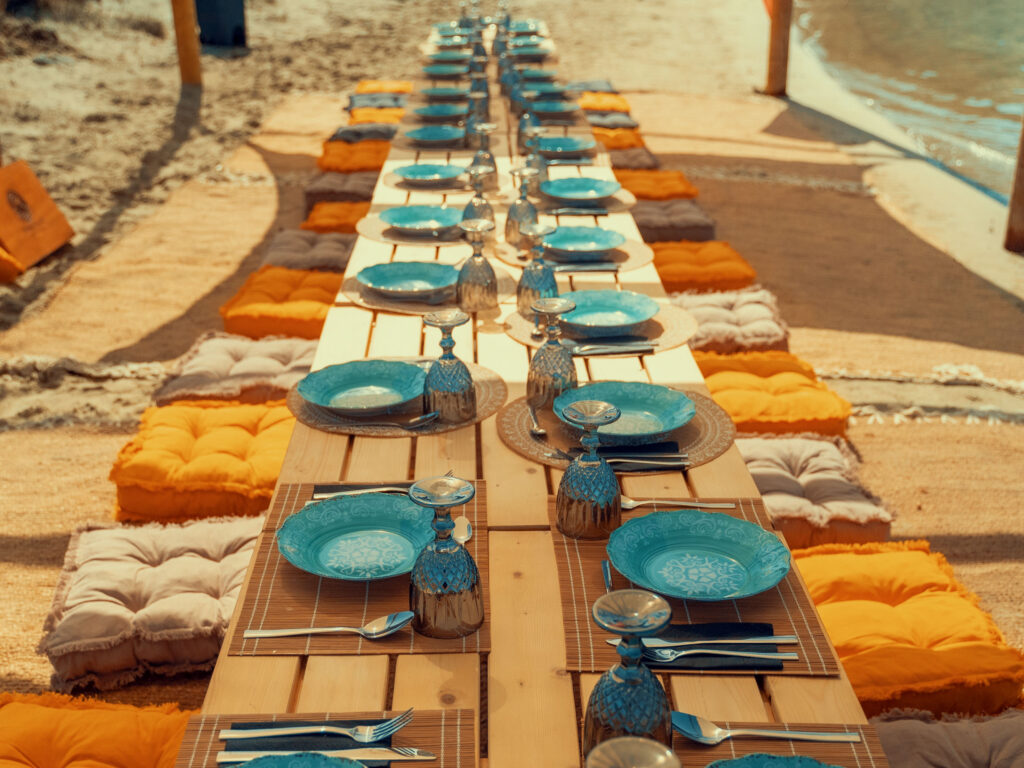 Luxury beach setup and private seaside dining organized for corporate retreats at sea, offering a unique tailor-made experience on a secluded shore.