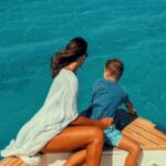 Mother and child admiring the stunning Aegean views from the safety of our yacht, a relaxing highlight of their family boat excursion.