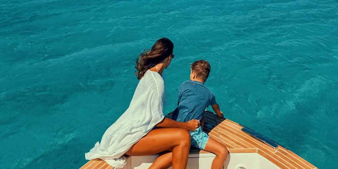Mother and child admiring the stunning Aegean views from the safety of our yacht, a relaxing highlight of their family boat excursion.
