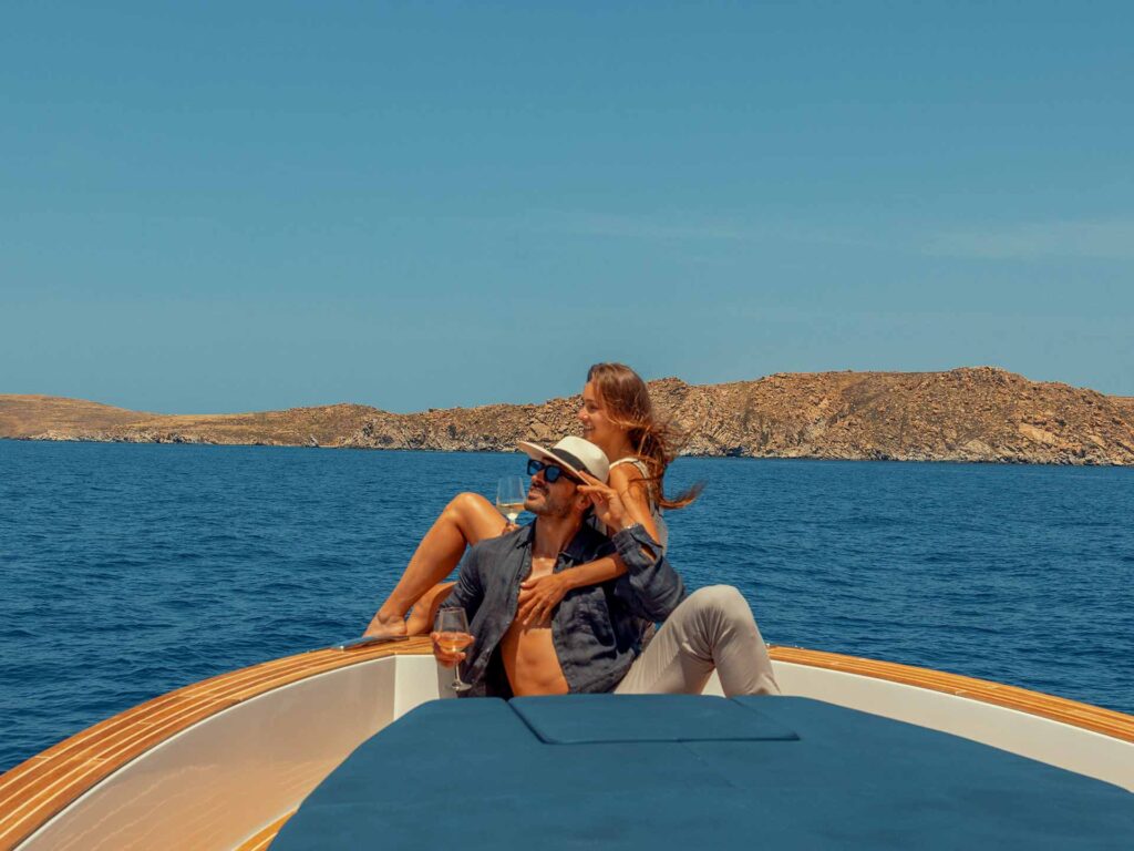A couple enjoying a romantic moment and the scenic view of the village from the deck, a must-see perspective when you visit Naousa Paros by private boat.