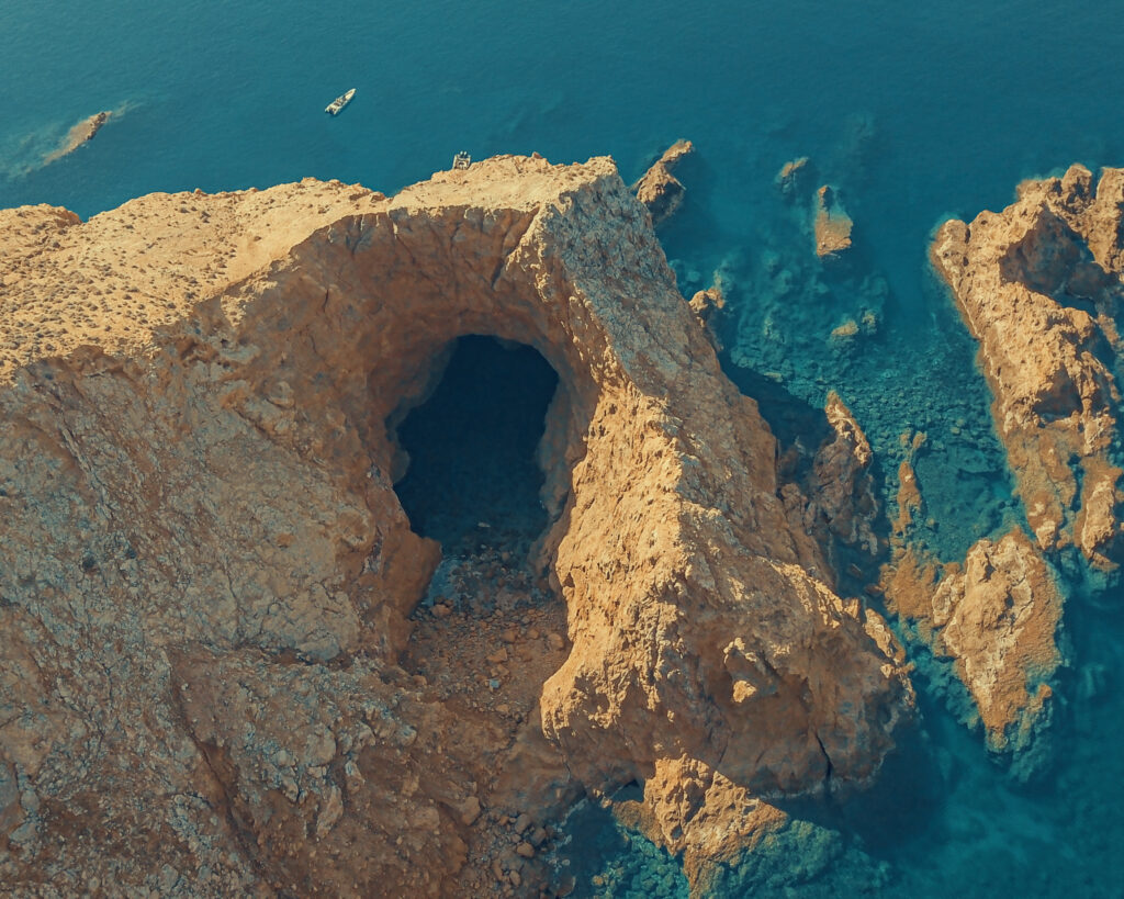 A luxury RIB boat navigating inside the famous sea caves of Dragonisi island near Mykonos