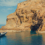 Panoramic view of the dramatic rocky cliffs and turquoise waters during a Dragonisi Mykonos Tour.