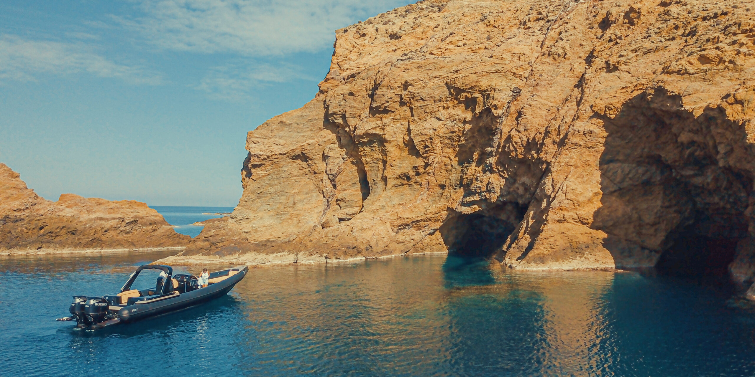 Panoramic view of the dramatic rocky cliffs and turquoise waters during a Dragonisi Mykonos Tour.