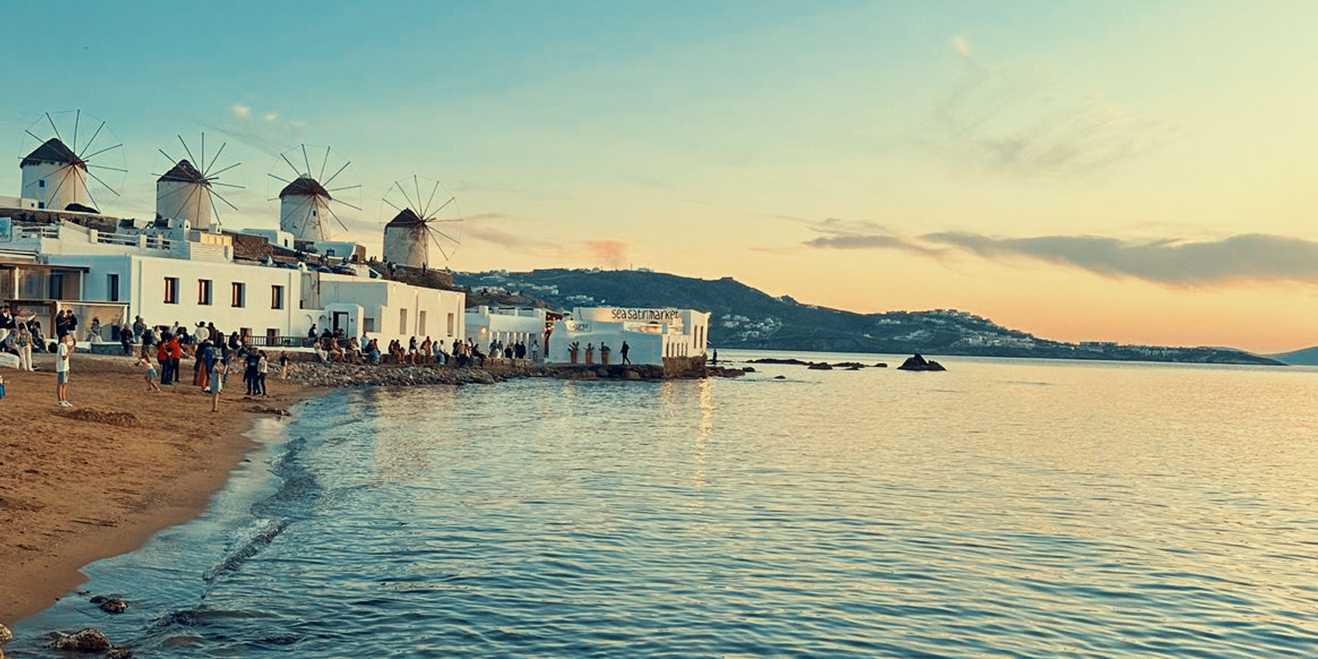 The iconic windmills of Mykonos bathed in golden sunset light — a timeless view that looks best when you've spent the day on a Don Blue Yachting private cruise during the best time to visit Mykonos