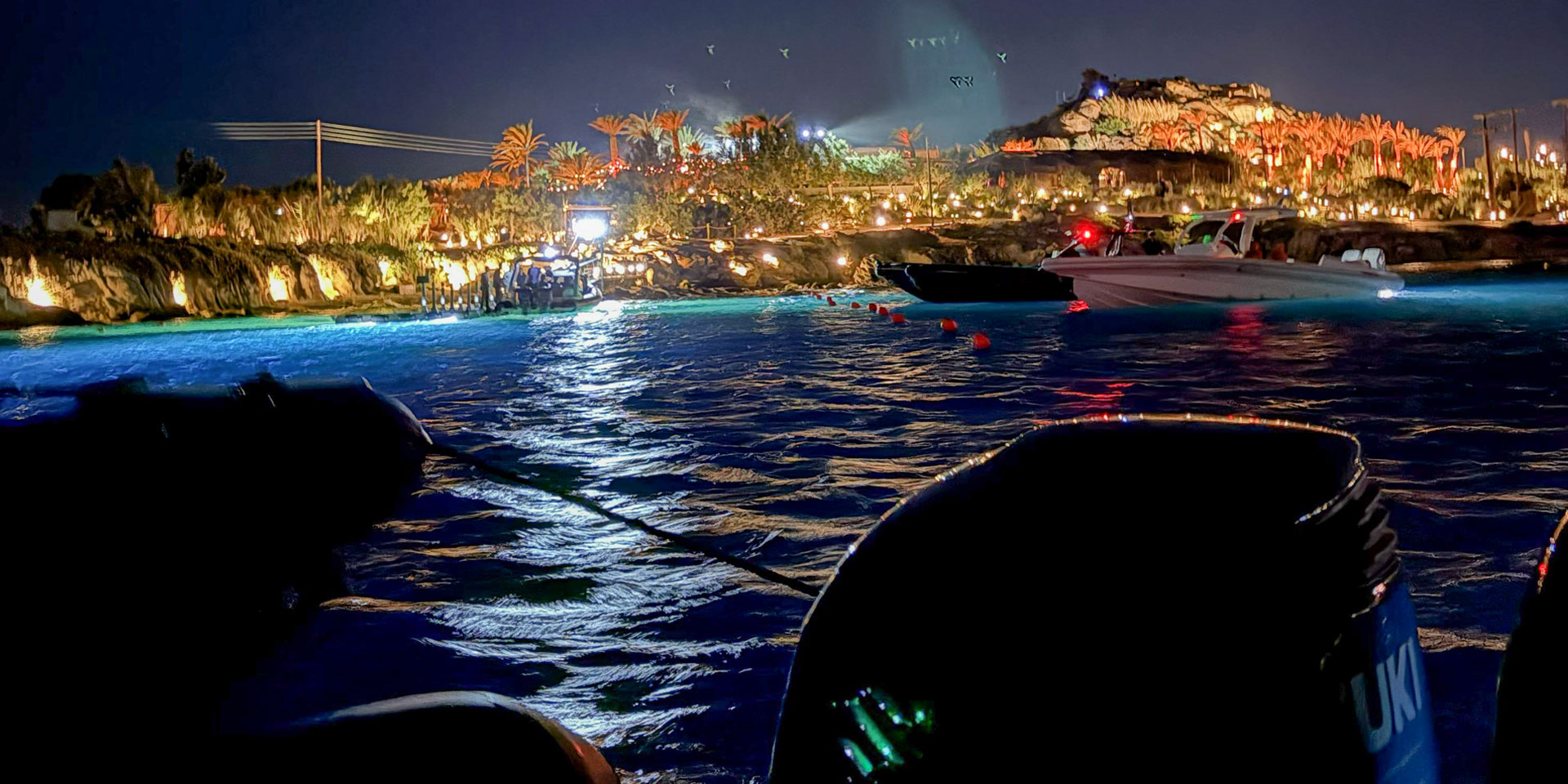 Don Blue Yachting private boat waiting offshore to transfer the DJ after a Keinemusik Scorpios Mykonos Music Ritual — the view from the water tells the whole story