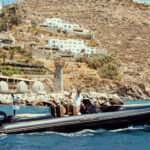Guests arriving by private boat to a Mykonos beach club with Don Blue Yachting