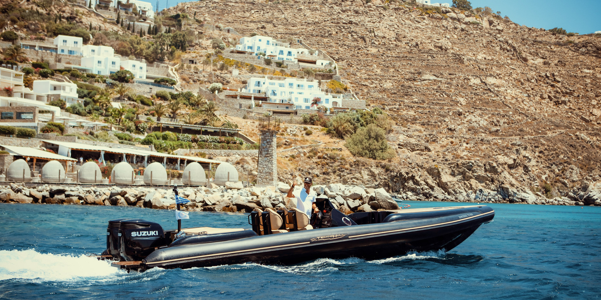 Guests arriving by private boat to a Mykonos beach club with Don Blue Yachting