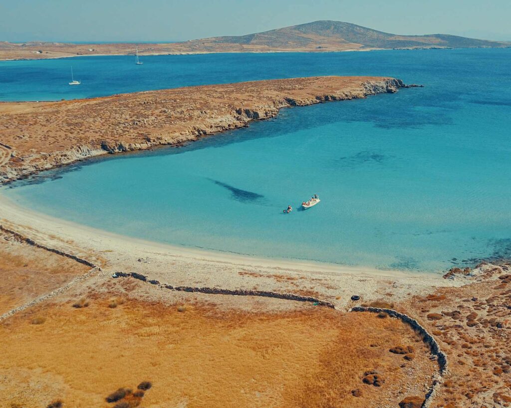 Aerial drone view of the pristine untouched beaches of Rhenia island near Mykonos — the hidden gem only reachable by boat and a highlight of any one day in Mykonos itinerary with Don Blue Yachting