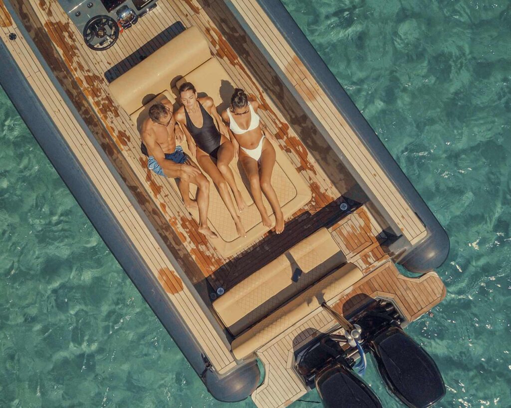 Aerial drone view of a group of friends enjoying the sun and sea aboard a Don Blue Yachting private boat — the ultimate way to avoid crowds in Mykonos and own the Aegean for a day.