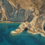 Aerial drone view of the rugged south coast beaches of Antiparos accessible only by boat — one of the hidden highlights of a Don Blue Yachting private cruise from Paros in Greece