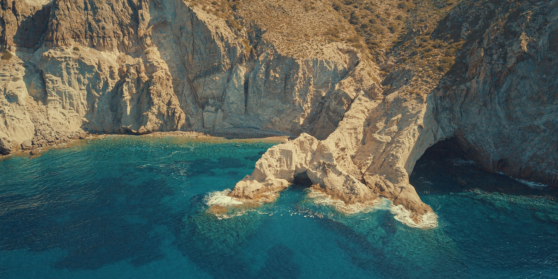 Aerial drone view of the rugged south coast beaches of Antiparos accessible only by boat — one of the hidden highlights of a Don Blue Yachting private cruise from Paros in Greece