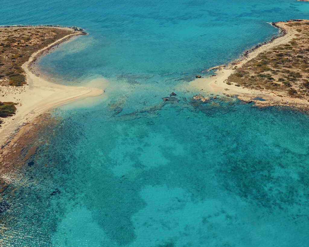Aerial drone view of the extraordinary turquoise waters and rocky islets of Panteronisia — the Caribbean of the Aegean, only reachable by boat on a Don Blue Yachting private cruise from Paros Greece
