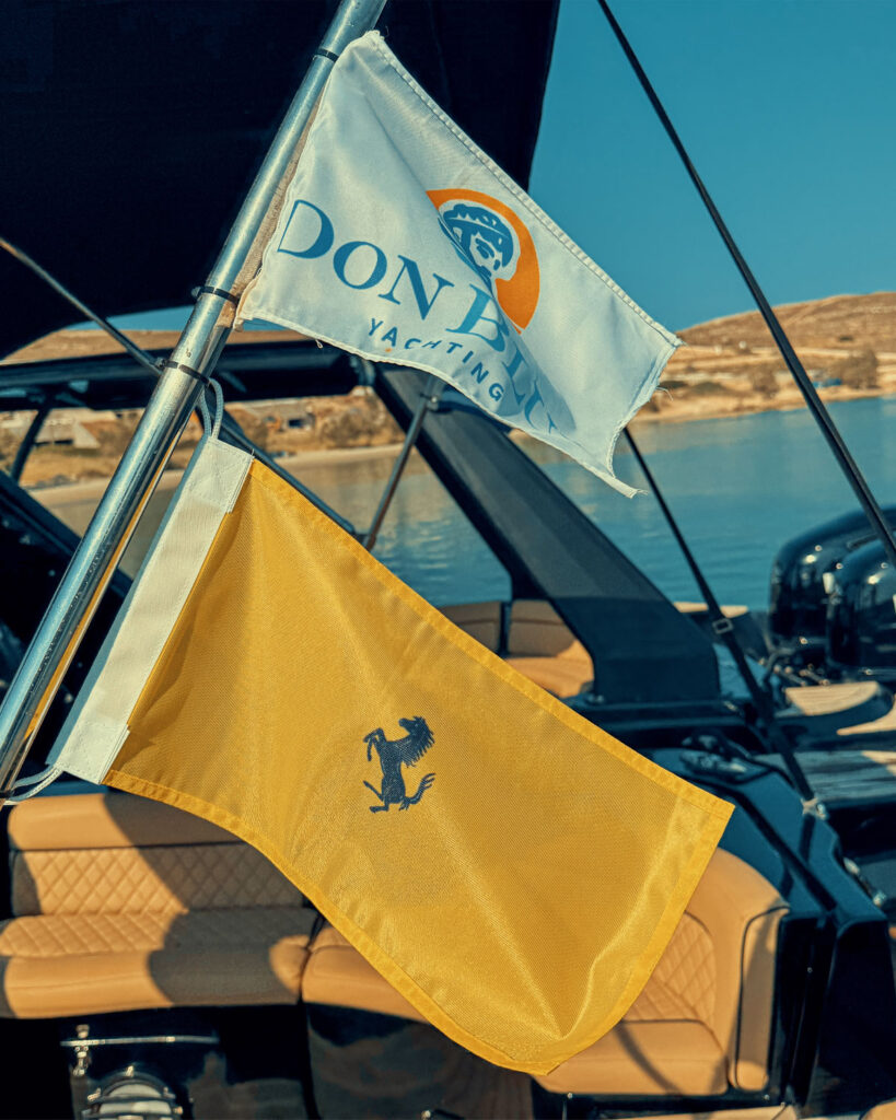 Don Blue Yachting boats flying Ferrari and Don Blue Yachting branded flags during the Ferrari Cavalcade 2026 Greece transfer operation in Paros
