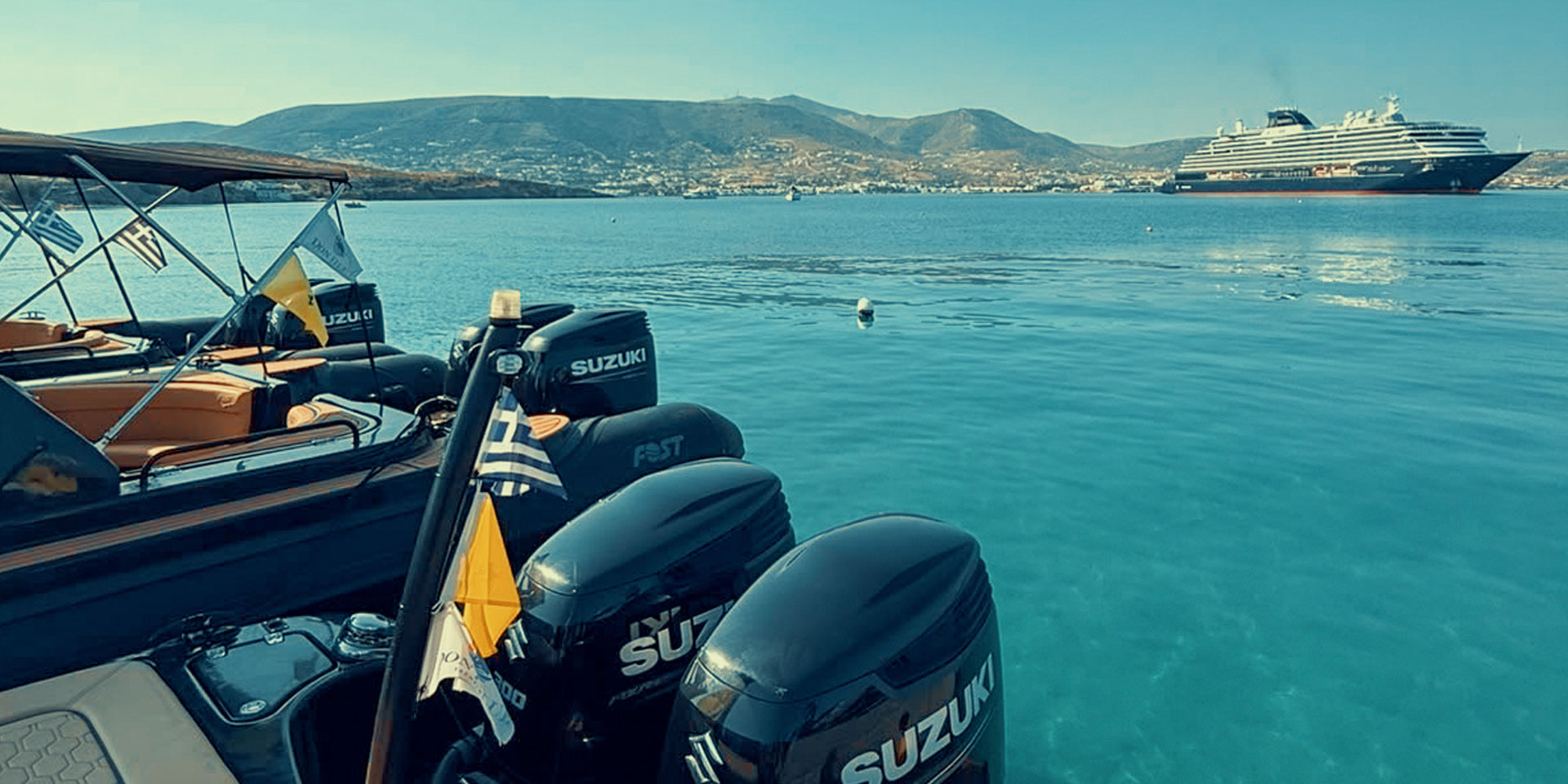 Don Blue Yachting boats docked at Crios Beach Paros with the EXPLORA II anchored in the background during the Ferrari Cavalcade 2026 Greece transfer operation