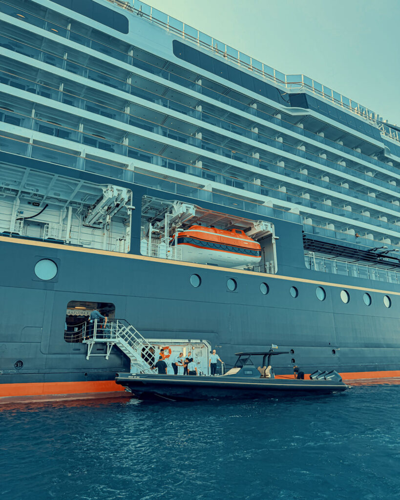 A Don Blue Yachting private RIB boat alongside the EXPLORA II during the boarding process — transferring Ferrari Cavalcade 2026 Greece VIP guests to Crios Beach Paros