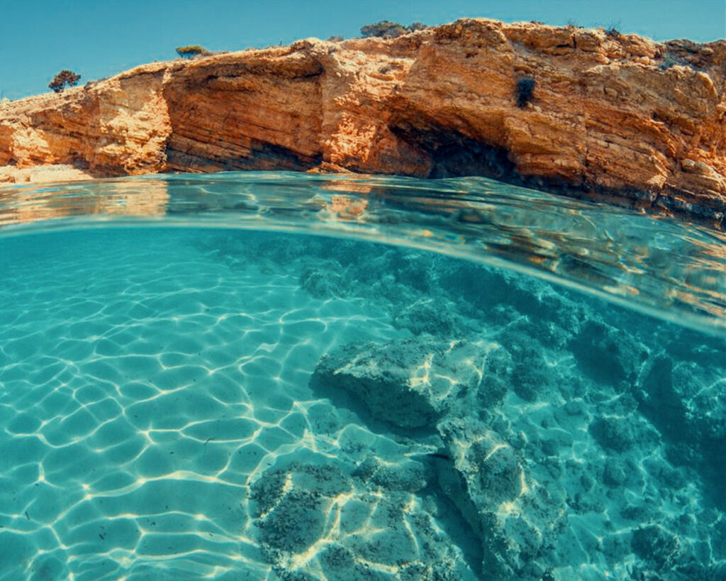 Sea caves carved into the eastern cliff face of Glaronisi Koufonisia explored by Don Blue Yachting private cruise