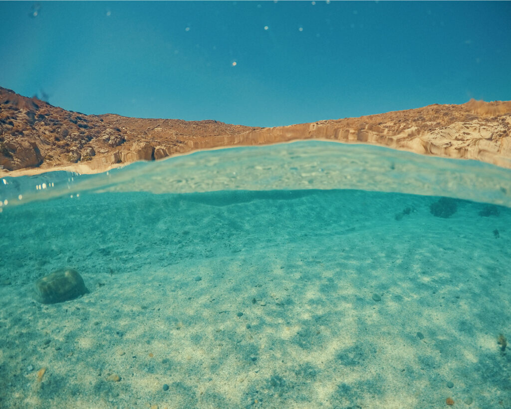 Underwater dome view of the crystal clear turquoise waters of Rhenia island near Mykonos during Steve Aoki's Don Blue Yachting private cruise